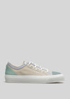 A V9 Antique-White & Lilac canvas low top sneaker with pale green accents and white laces against a solid gray background.