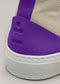 Close-up of a TH0009 by Sofia high top sneaker with a beige canvas upper and bright purple suede heel tab embossed with the logo "lio".