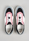 A pair of N0003 by Márcia low top sneakers with pink and black panels, white laces, and branded with "d'verge" on the insole.