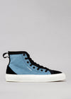 TH0005 by Mónica, a blue and black high-top sneaker on a grey background, featuring a white sole and black laces, designed for men.