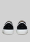 Rear view of TL0002 by Roni low top sneakers with white soles and black laces on a light gray background.