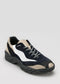A single L0005 by Tiago navy and white low-top sneaker with a chunky sole, displayed on a grey background.