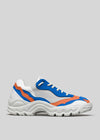 V18 Leather Color Mix Electric Blue low top sneaker with blue and orange panels and a chunky, wavy sole, displayed against a light gray background.