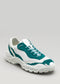 A single V3 Leather Color Mix Emerald low top sneaker with a chunky sole, displayed against a neutral gray background.