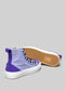 A pair of TH0001 by Leandra high-top canvas sneakers with purple and white coloration, featuring a white sole and exposed gum rubber outsole.