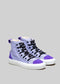 A pair of TH0001 by Leandra high-top canvas shoes with purple and white panels and black laces, displayed against a neutral gray background.