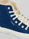 Close-up of a DiVERGE X BUREL Midnight Blue high-top sneaker with white laces and the word "d-verge" printed on the side, crafted from canvas.