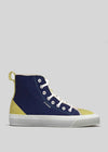 High-top canvas sneaker in DiVERGE X BUREL Midnight Blue color blocks with white laces and a white rubber sole, displayed against a gray background.