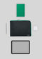 Flat lay of black tech accessories including a tablet, stylus, green notebook, M Leather Pouch Black w/Green, and wireless earphones on a gray background.