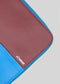A close-up view of a M Patchwork Pouch Bordeaux & Blue laptop sleeve with the word "diverge" printed on the lower right.
