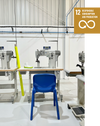 Una scarpa personalizzata accanto a una macchina da cucire in un ambiente di produzione responsabile.
