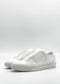 The ML0115 White Leather sneakers, crafted from premium Italian leathers, feature a plain design and are shown from the side against a light background, highlighting their elegant simplicity. Handcrafted in Portugal for an ideal combination of style and comfort.