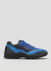 The L0015 by Iara is a blue and black athletic shoe with a layered design, featuring thick tread soles and lace-up closure, handcrafted from premium Italian leathers, displayed against a plain gray background.