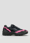 The L0015 by Becas, a black athletic shoe with pink accents, a chunky sole, and black laces, is displayed against a plain background, impeccably crafted from premium Italian leathers.