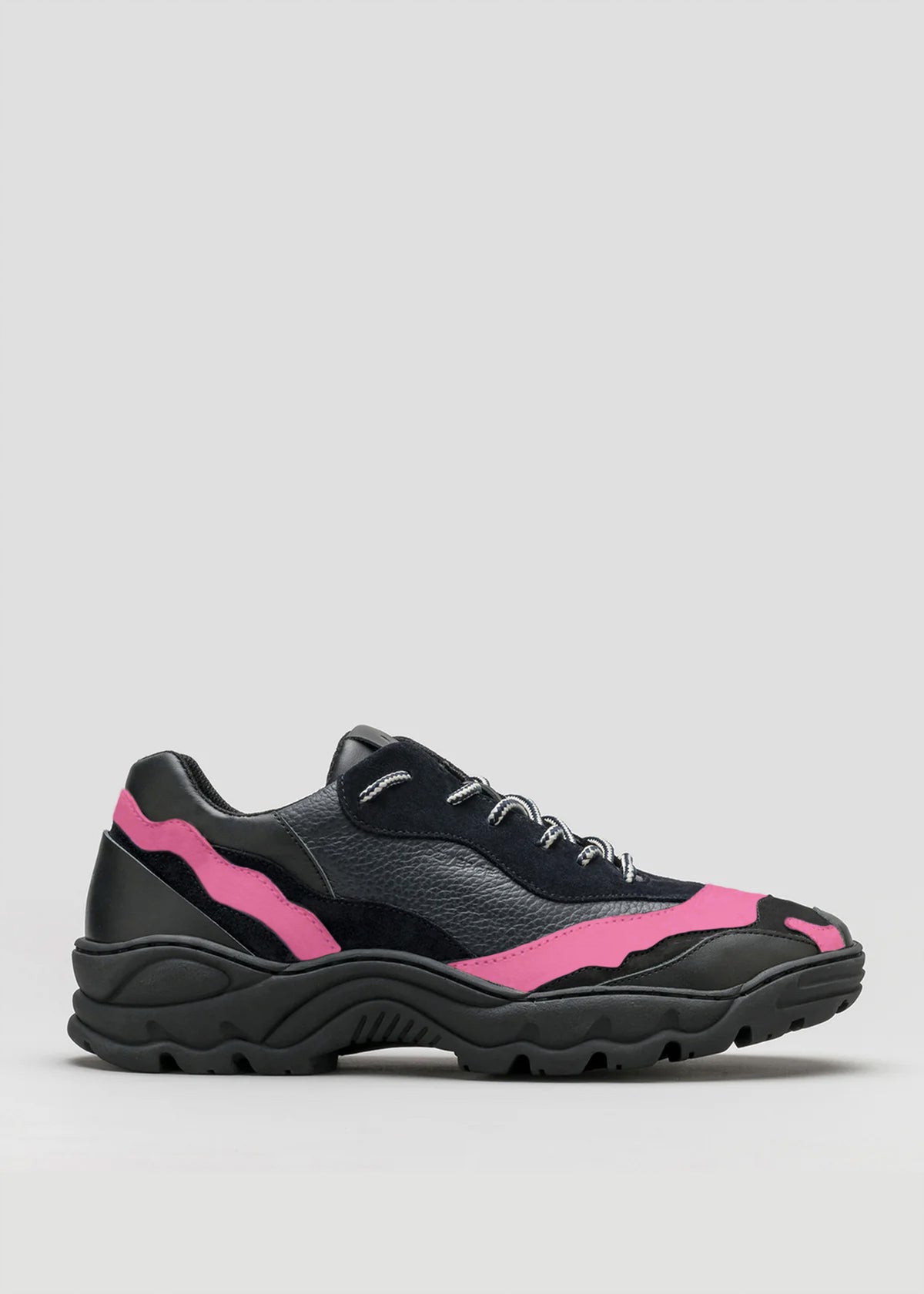 The L0015 by Becas, a black athletic shoe with pink accents, a chunky sole, and black laces, is displayed against a plain background, impeccably crafted from premium Italian leathers.