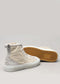 Two light beige high-top sneakers, handcrafted in Portugal, positioned on a plain background, showing both the outer side and the gum-colored sole with a hexagonal pattern — these are TH0015 by Sofia.