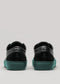 Back view of V49 Black W/ Forest Green sneakers crafted with premium Italian leathers, featuring teal soles against a light gray background.