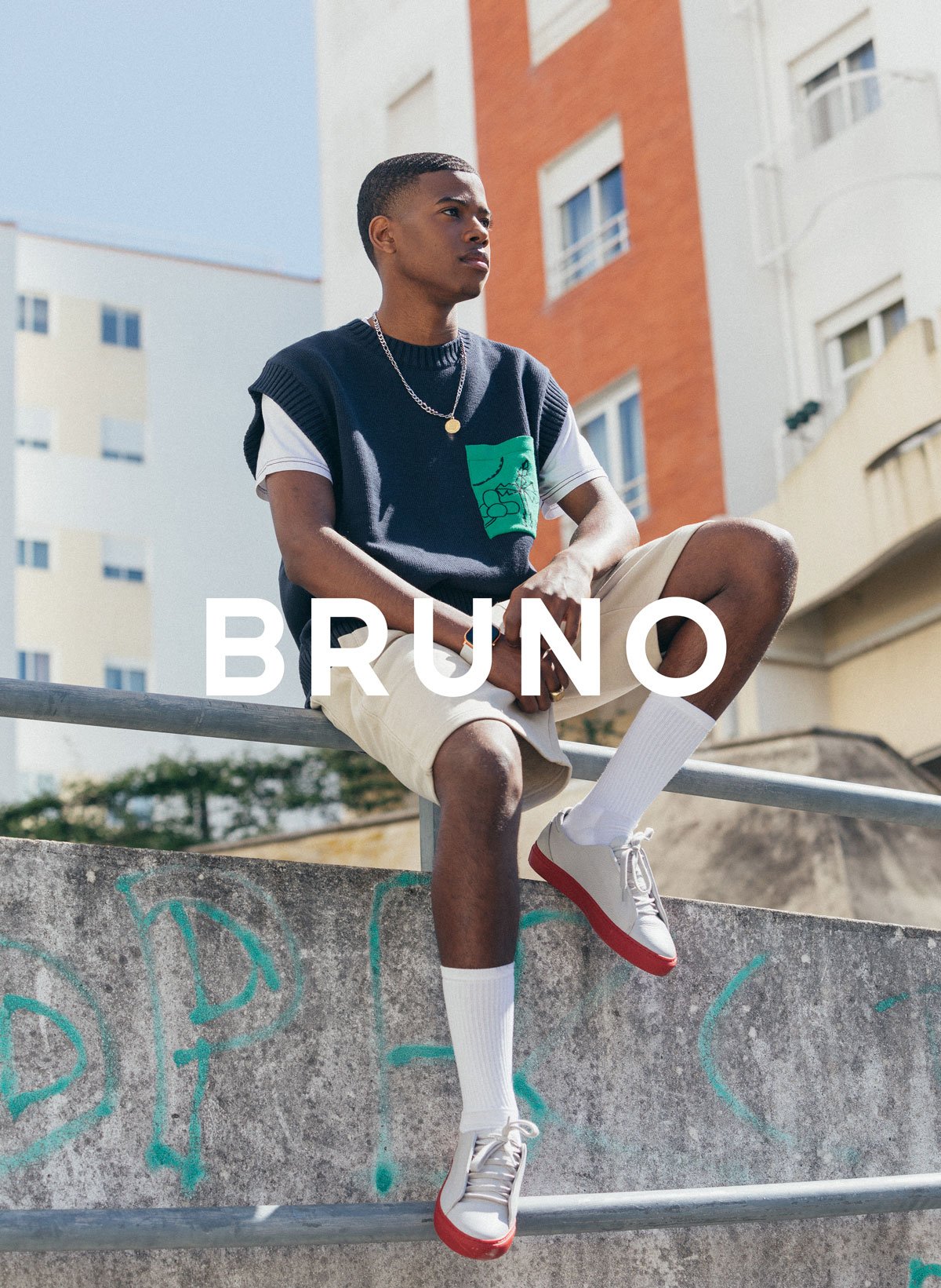Bruno seduto su un corrimano, indossando Diverge sneakers, promuovendo l'impatto sociale e le scarpe personalizzate attraverso il progetto Imagine. 