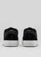 A pair of V46 Black Floater sneakers, handcrafted in Portugal with premium Italian leathers, showcasing black uppers and white soles, viewed from the back against a neutral background.