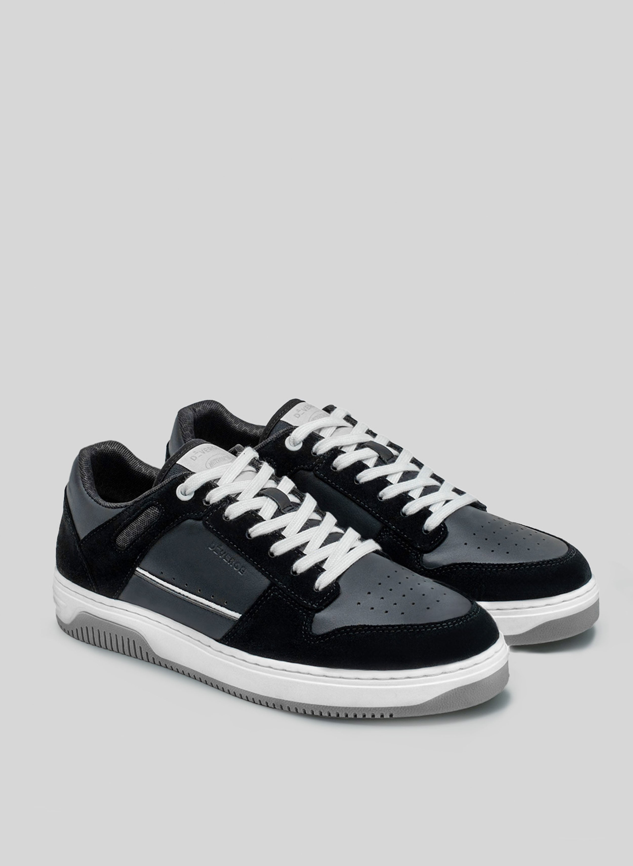 sneakers bianco e nero con suola grigia di Diverge, che promuove l'impatto sociale e le scarpe personalizzate attraverso il progetto imagine. 