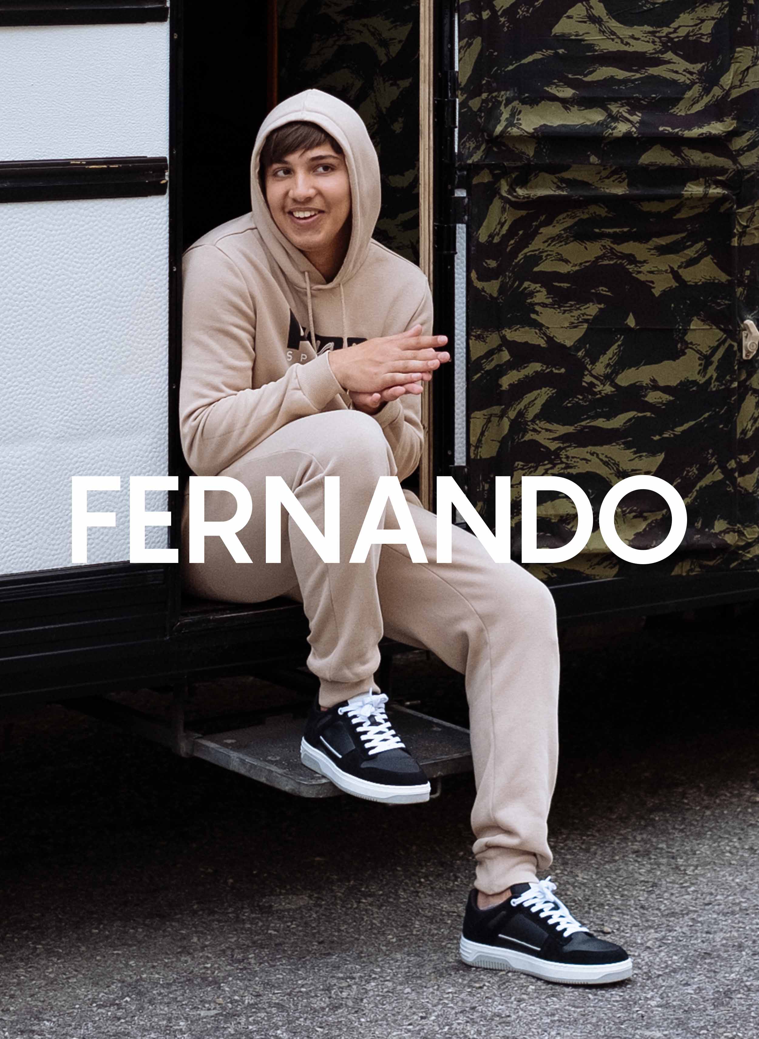 Fernando seduto in un camper, che indossa Diverge sneakers, promuovendo l'impatto sociale e le scarpe personalizzate attraverso il progetto Imagine.