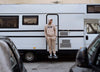 A man at the door of a motorhome looking away, wearing Diverge sneakers, promoting social impact and custom shoes throught the imagine project.