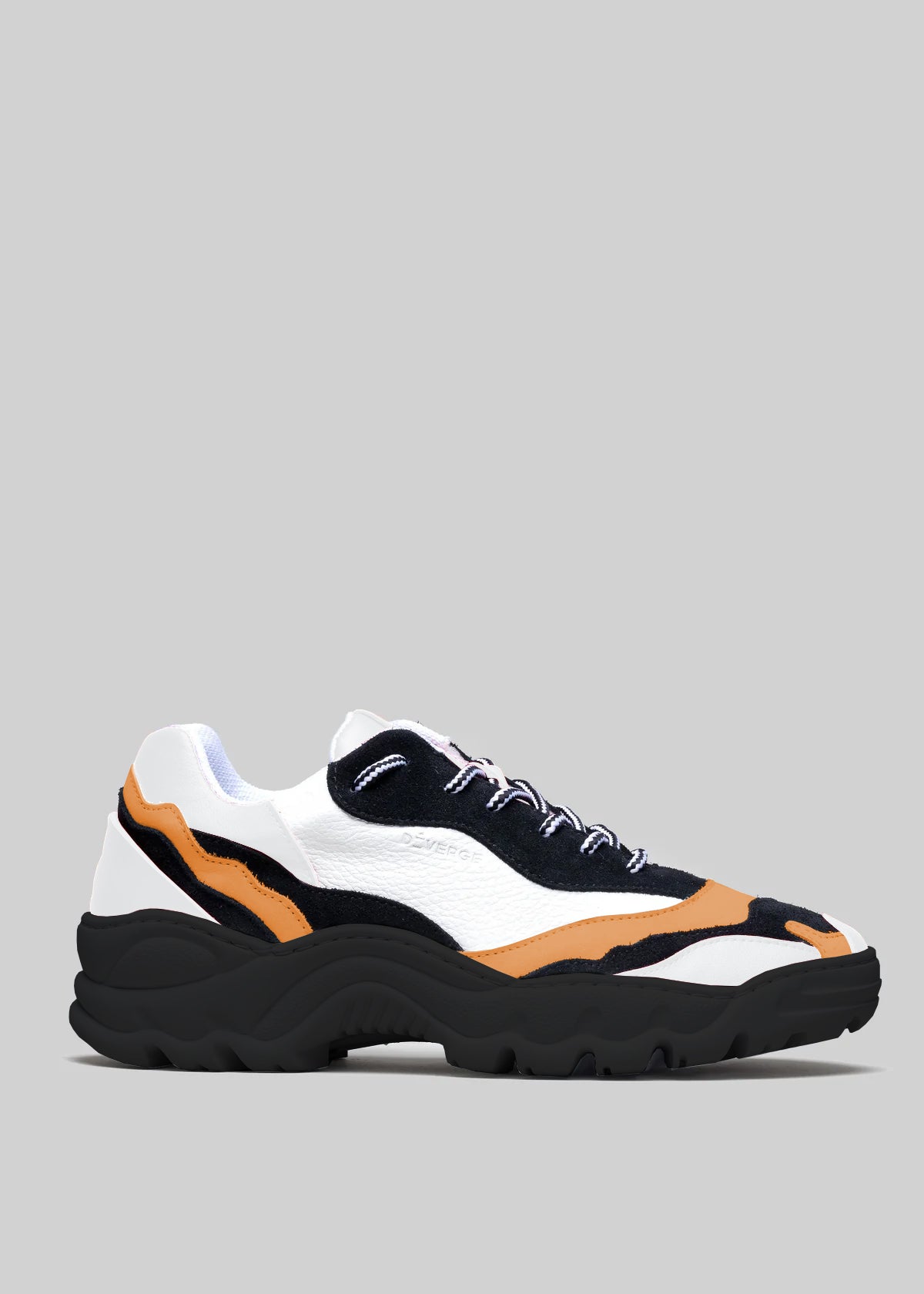The L0022 by Alexandre is a black, white, and orange sneaker with premium handcrafted Italian leather and a chunky black sole set against a gray background.