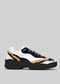 The L0022 by Alexandre is a black, white, and orange sneaker with premium handcrafted Italian leather and a chunky black sole set against a gray background.