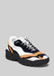 L0022 by Alexandre features a handcrafted design with a white, black, and orange patterned upper, a chunky black sole, and black and white laces. Made from premium Italian leathers for exceptional quality and style.