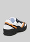 The L0022 by Alexandre are premium handcrafted sneakers with a black sole, white and black upper, and vibrant orange accents, showcased from the rear against a gray background.