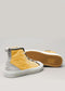 Two TH0020 by Leonardo premium canvas high-top sneakers are showcased on a solid background. Crafted in Portugal, they feature yellow and gray tones with white soles, hexagonal sole patterns, and silver eyelets for the laces.