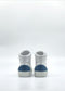The MH0143 White & Blue high-top sneakers, handcrafted in Portugal, featuring blue patches on the heels, are viewed from the back against a plain white background.