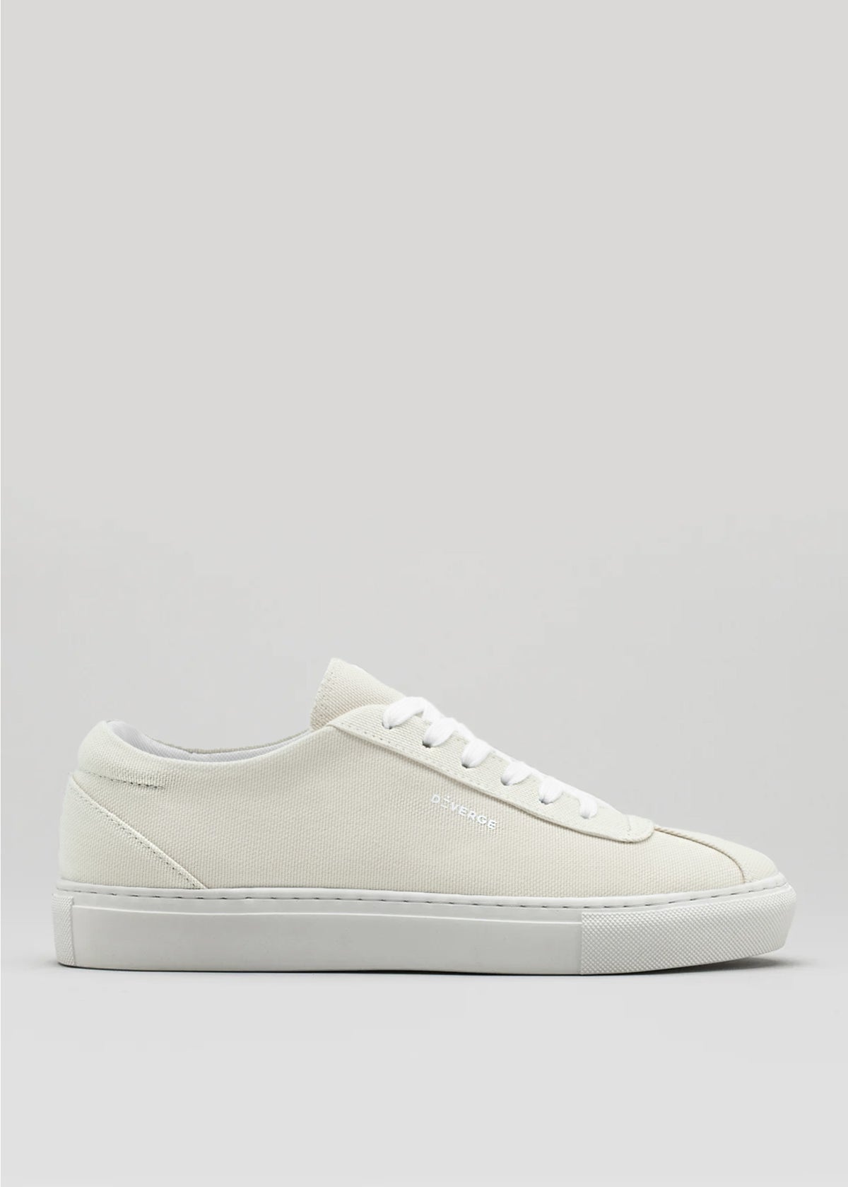 A side view of the V1 Antique White low-top sneaker, ethically crafted with premium canvas, showcasing a minimalist design on a neutral background.