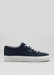 Introducing the V3 Marine: a handcrafted canvas sneaker in navy blue, featuring white laces and a sleek rubber cupsole. Made in Portugal, this stylish shoe includes elegant branding on the side set against a plain background.