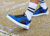A person wearing custom blue and black low top sneakers by Diverge, promoting social impact.