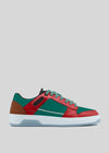 The M0022 by Daniel sneaker showcases a retro-future design with a red, green, and brown upper, a black heel patch, and premium Italian leather construction. It features a white sole and is set against a plain gray background.