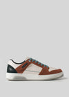 The M0023 by André showcases a retro-future style with a brown and white leather upper made from premium Italian materials, teal laces, and a white rubber sole, set against a plain gray background.