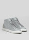 Explore the V55 Light Grey W/ Bone high tops, customizable in light gray with a white sole. Made from premium leather and handcrafted, these stylish and versatile sneakers are set against a plain gray background.