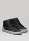 The V56 Black W/ Bone sneakers, handcrafted in Portugal using premium Italian leathers, showcase black uppers with white soles and gray heel accents against a neutral background, effortlessly blending style and quality.