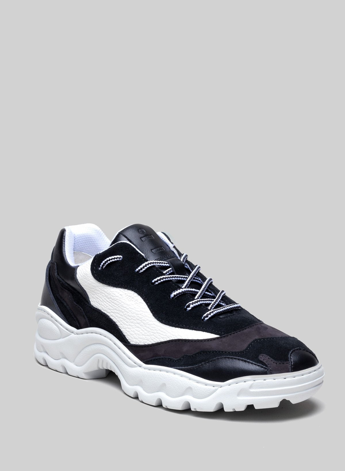 Sneaker in bianco e nero di Diverge, che promuove l'impatto sociale e le scarpe personalizzate.
