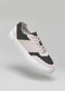 The V29 Bone & Black sneakers, handcrafted in Portugal with premium Italian leathers, float gracefully against a light gray background featuring a pristine white sole.