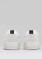 Rear view of the V31 White & Plaster sneakers featuring black heel-tabs, crafted in Portugal from premium Italian leathers, with a minimalist design on a light gray background.