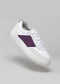 The V37 White W/ Plum sneaker is handcrafted with a purple stripe on the side, featuring white laces and a thick white sole made from premium Italian leathers, set against a plain gray background.