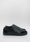 Un paio di SO0014 Black Floater slip-on sneakers su uno sfondo grigio chiaro.