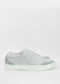 Una singola sneaker slip-on SO0018 Grey W/ White in pelle con suola bianca, visualizzata su uno sfondo bianco.