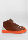 A pair of MH0075 Argil W/ Orange high-top sneakers with white laces and an orange sole, displayed against a plain white background.