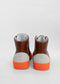A pair of MH0075 Argil W/ Orange high top sneakers with bright orange soles, viewed from the back on a white background.