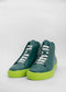 Un par de MH0064 Green W/ Yellow high top sneakers, mostrados sobre un fondo blanco liso.