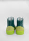 A pair of MH0064 Green W/ Yellow leather boots with bright yellow soles, viewed from the back, against a white background.