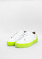 Un par de ML0036 de cuero blanco W / amarillo sneakers, hecho a la medida sobre un fondo gris.